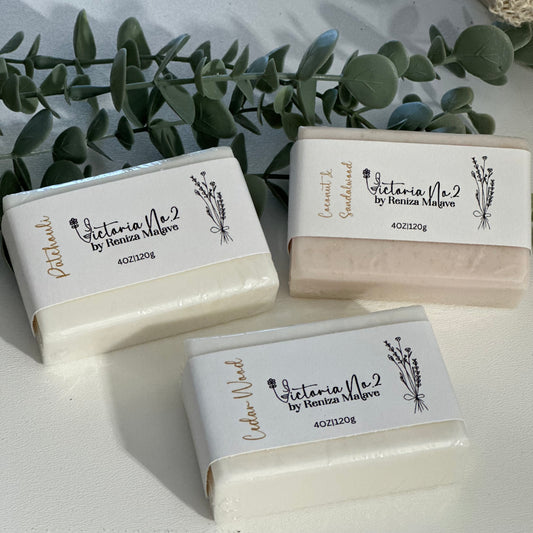 Three bars of soap with 'Victoria Vie' branding on a light background with greenery.